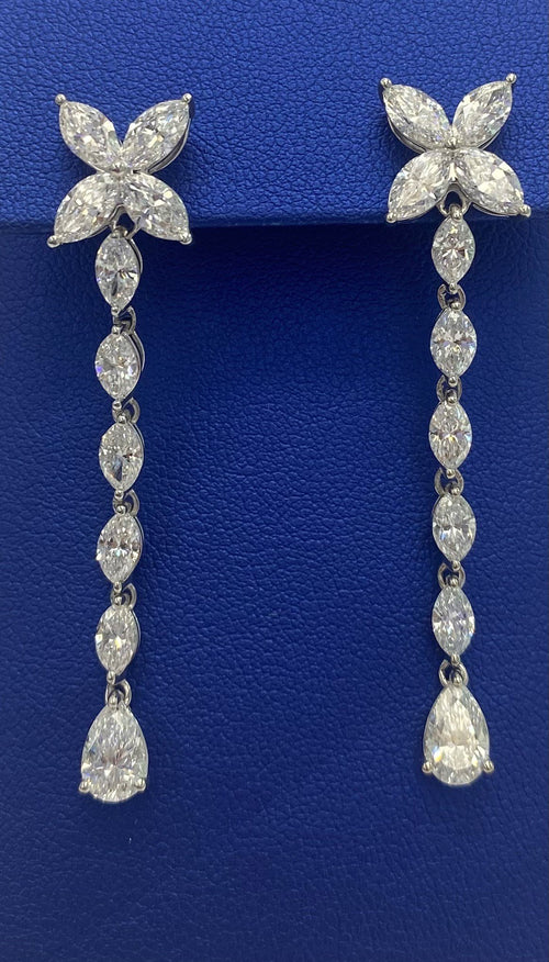 A pair of The DiamondLab MARQUISE diamond drop earrings on a blue background.